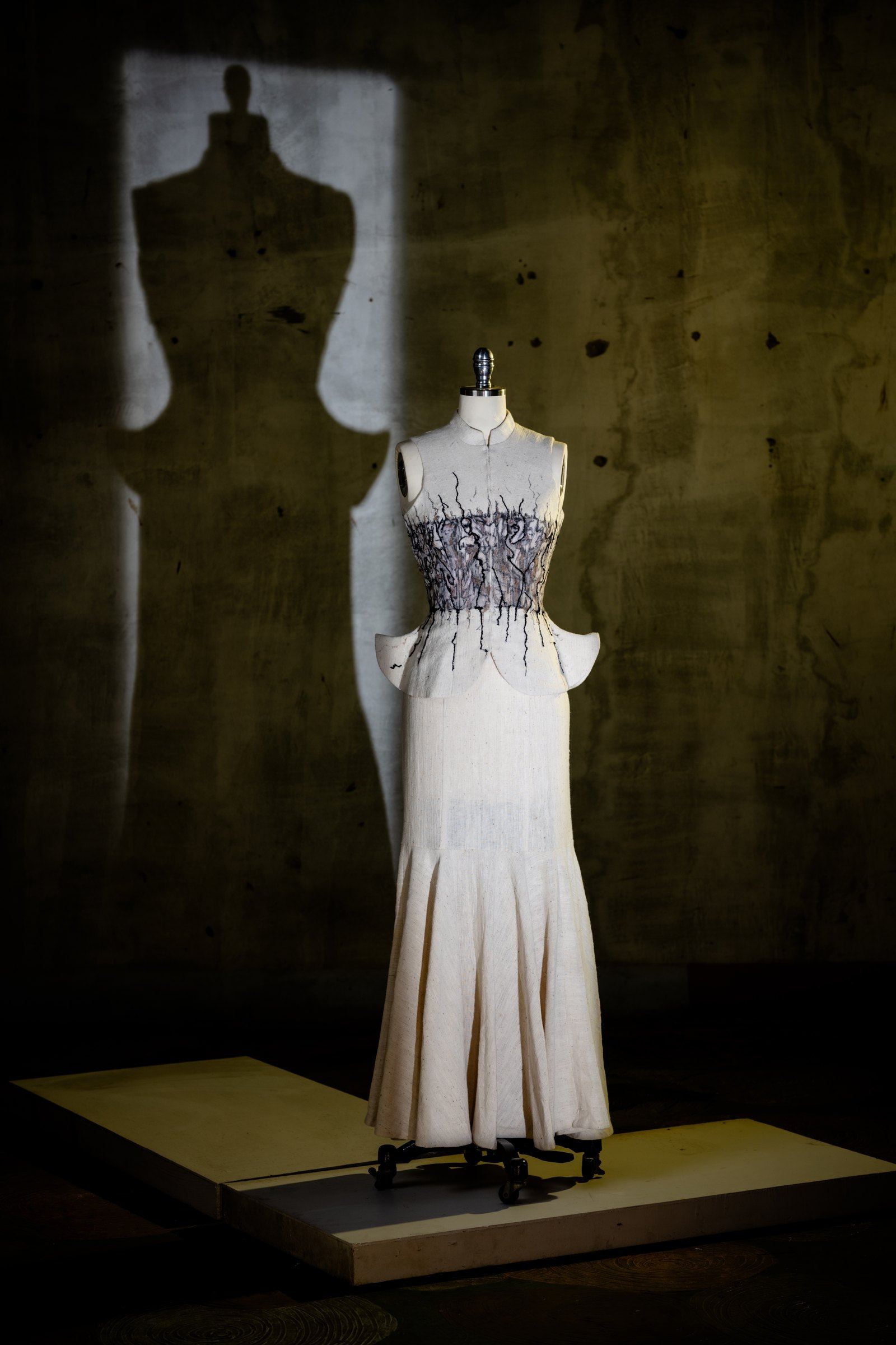 The column gown on the stand, hand-finished at the hem